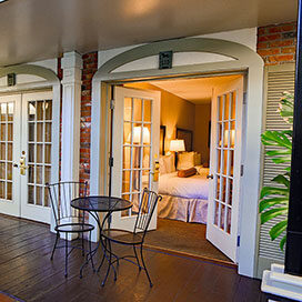 two queen beds guest room with french doors and atrium view